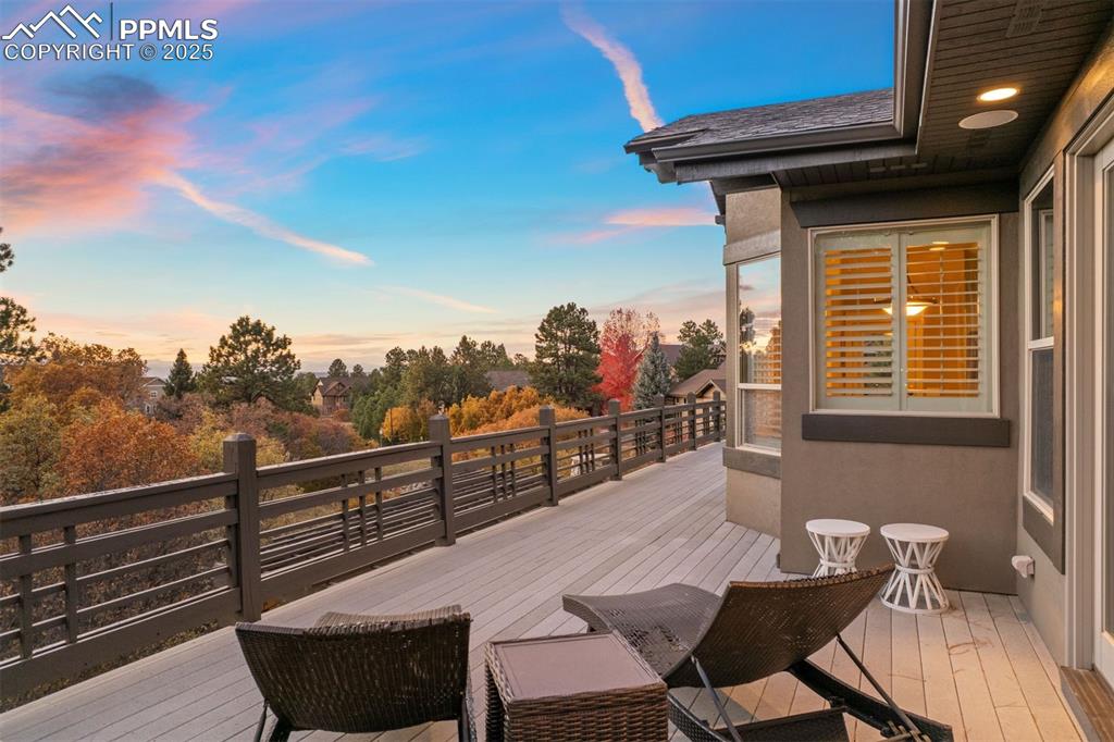 Image 10 of 50: Wooden deck featuring view of scattered trees
