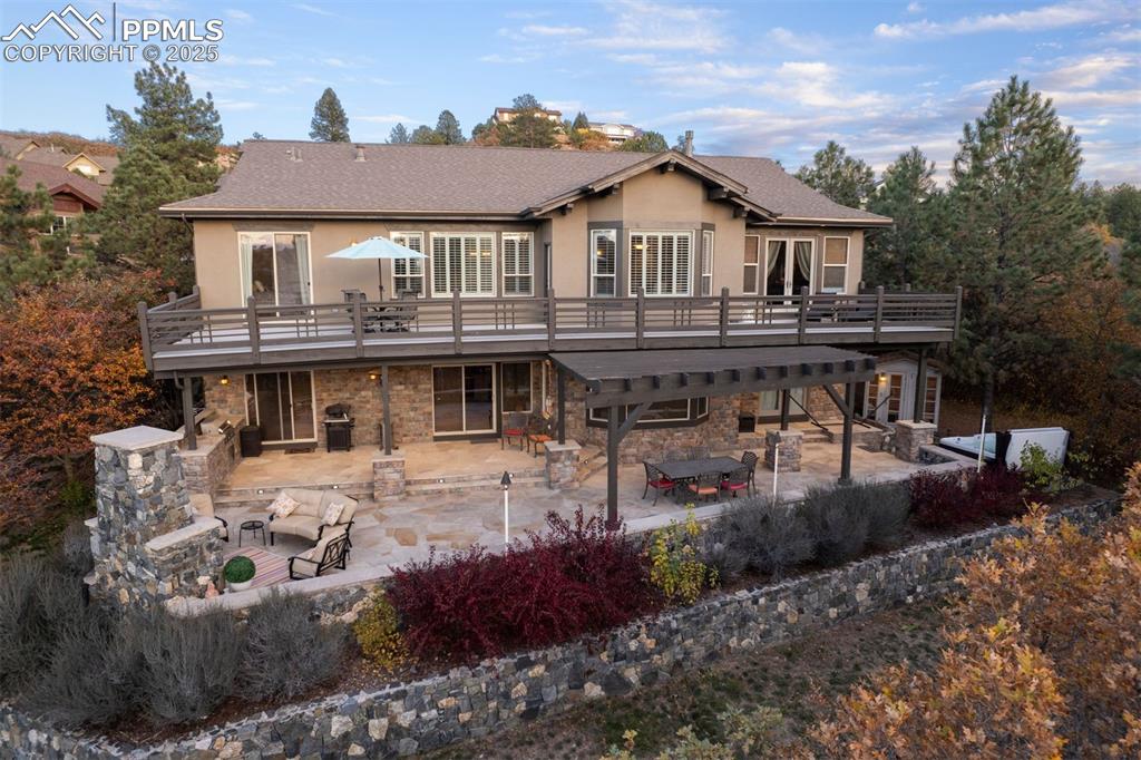 Image 11 of 50: Rear view of property featuring a patio area, stucco siding, a deck, and st