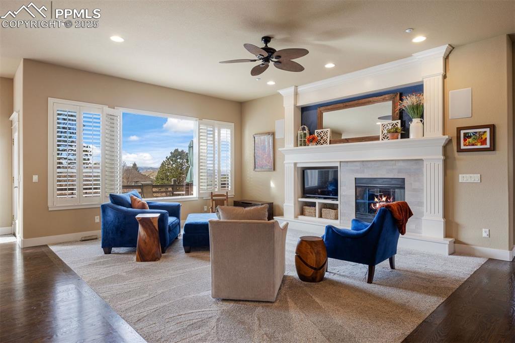 Image 13 of 50: Living area with wood finished floors, a tile fireplace, recessed lighting,