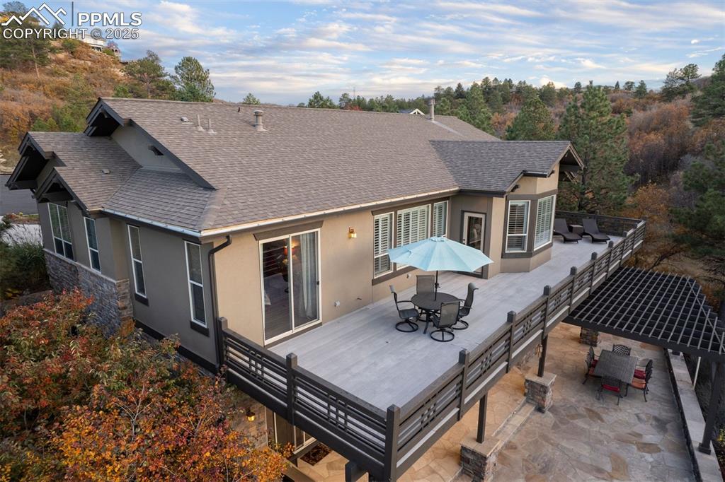 Image 30 of 50: Back of property featuring outdoor dining area, a shingled roof, stucco sid