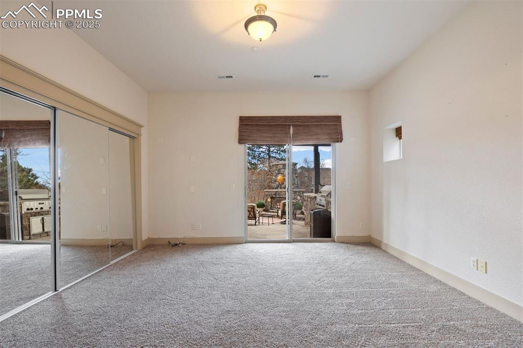 Image 38 of 50: Unfurnished bedroom featuring access to outside, carpet flooring, and a clo