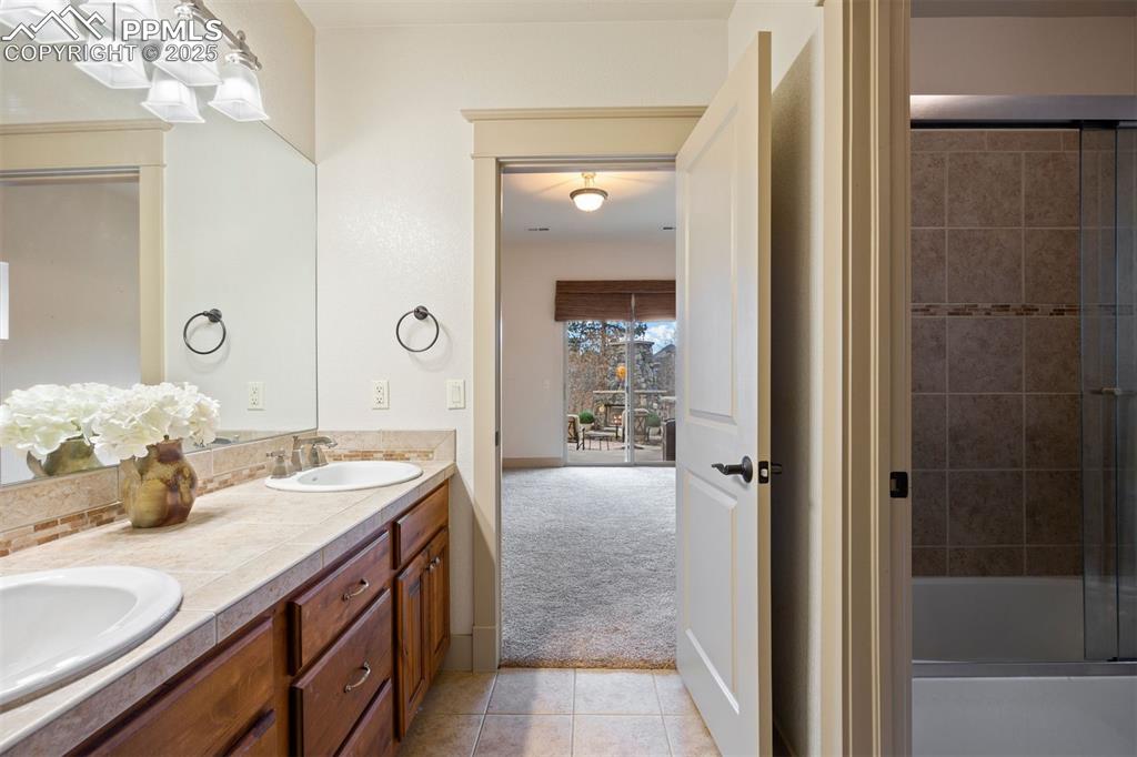 Image 40 of 50: Full bathroom featuring light tile patterned floors, double vanity, light c