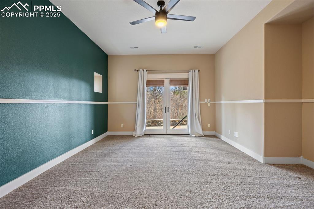 Image 44 of 50: Spare room with carpet, a textured wall, french doors, and ceiling fan