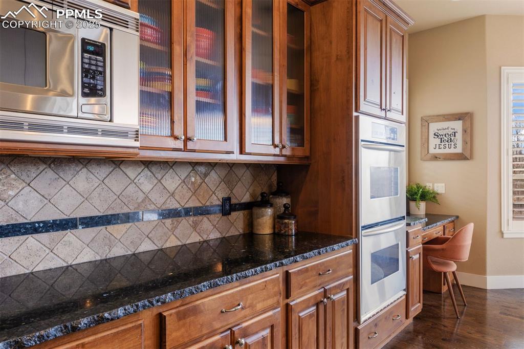 Image 5 of 50: Kitchen with appliances with stainless steel finishes, dark stone counterto