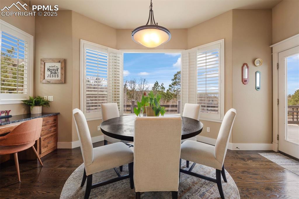Image 7 of 50: Dining area with healthy amount of natural light and dark wood finished flo