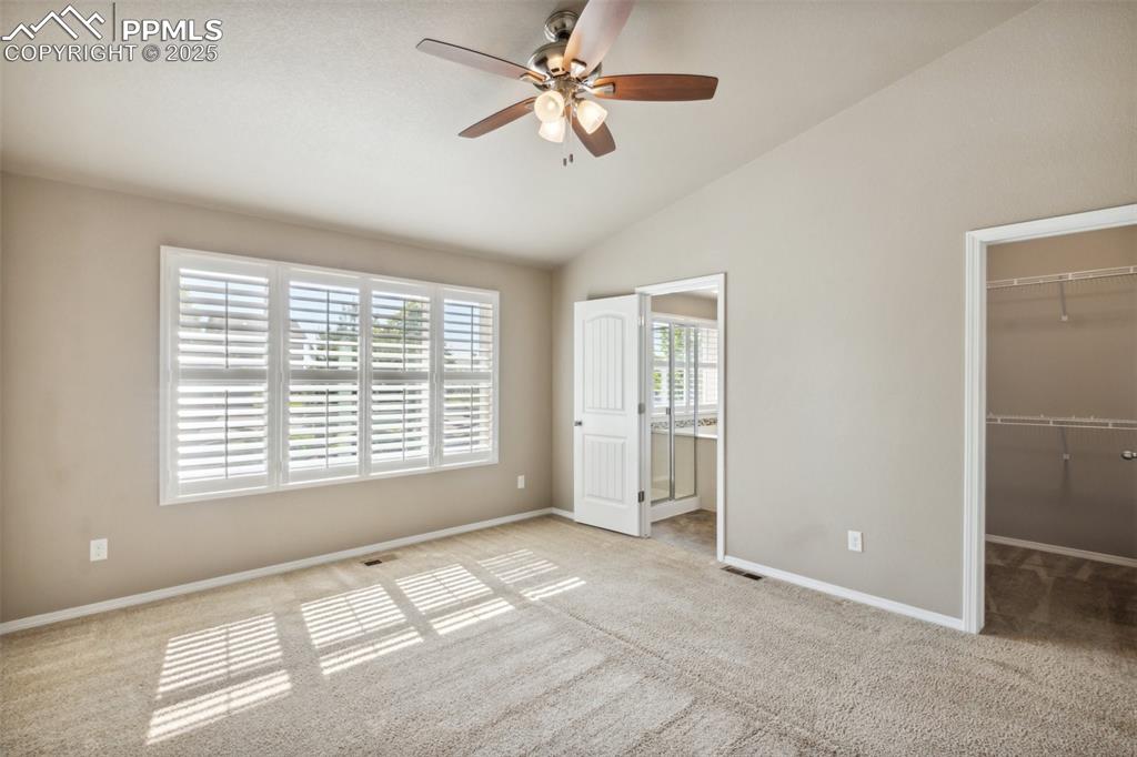 Image 12 of 50: Bedroom featuring a spacious closet, carpet, lofted ceiling, a closet, and 