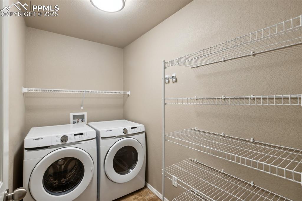 Image 17 of 50: Laundry area with washing machine and clothes dryer and storage capacity