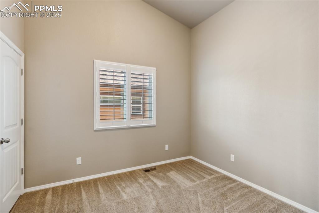Image 18 of 50: Carpeted spare room featuring baseboards and vaulted ceiling