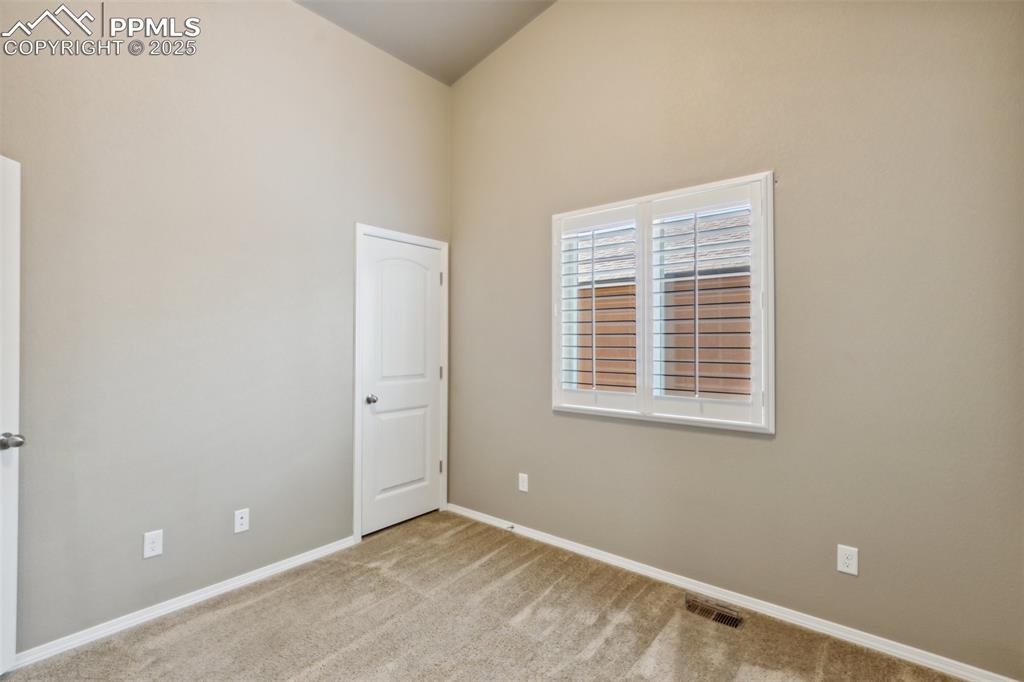 Image 19 of 50: Carpeted empty room with baseboards and high vaulted ceiling