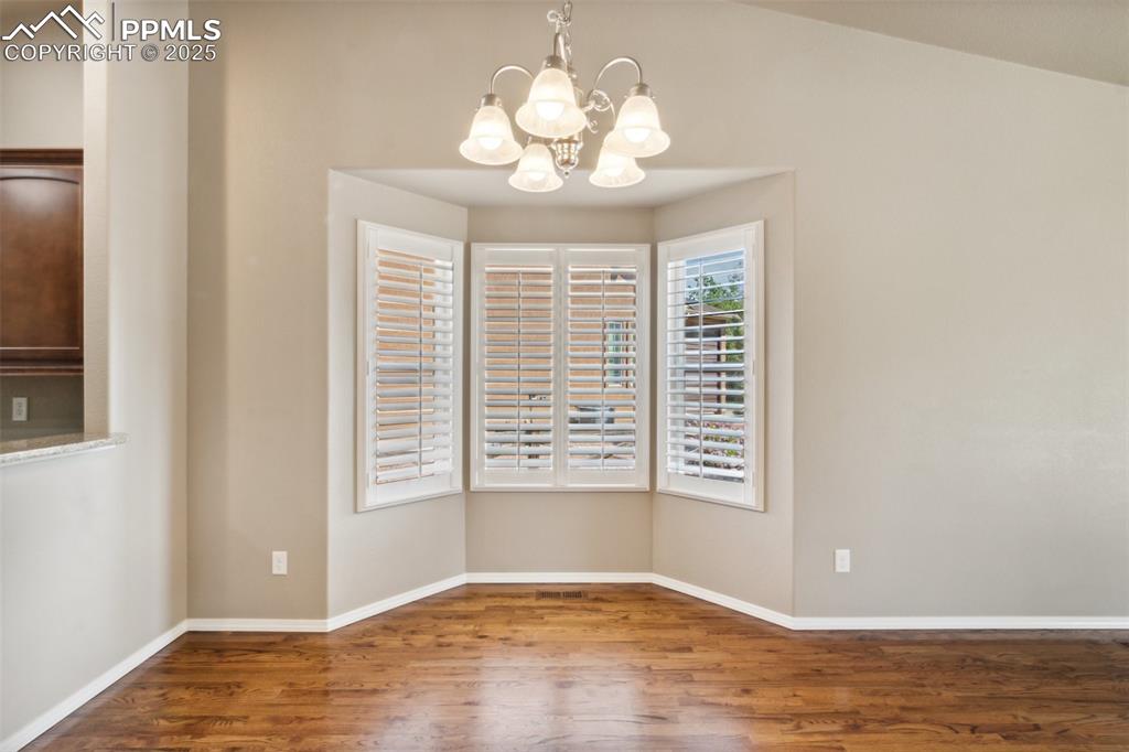 Image 24 of 50: Dining area featuring wood finished floors, a chandelier, and baseboards