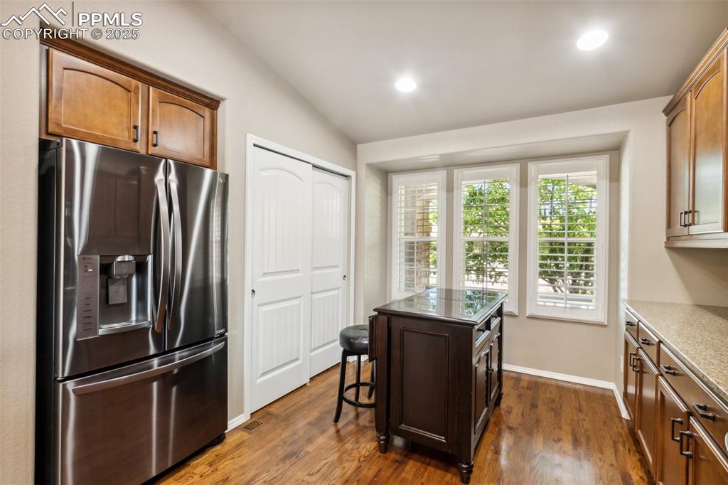 Image 25 of 50: Kitchen featuring stainless steel fridge, dark wood-type flooring, recessed