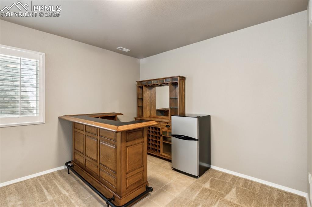 Image 29 of 50: Wet bar and light colored carpet