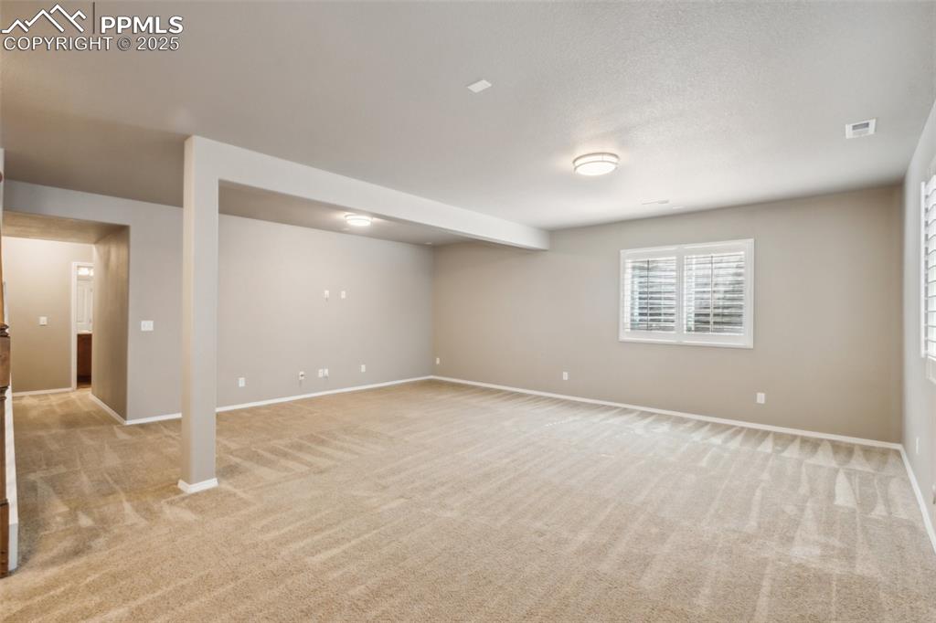 Image 31 of 50: Basement featuring light carpet