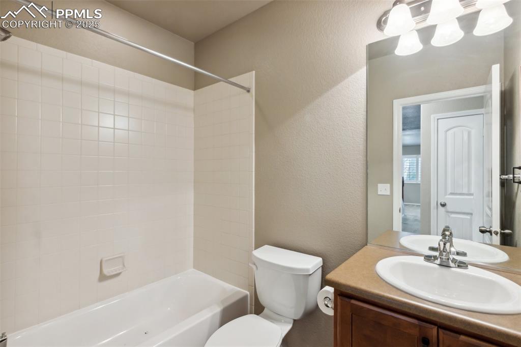 Image 34 of 50: Bathroom Downstairs with toilet, shower / washtub combination, vanity, and 