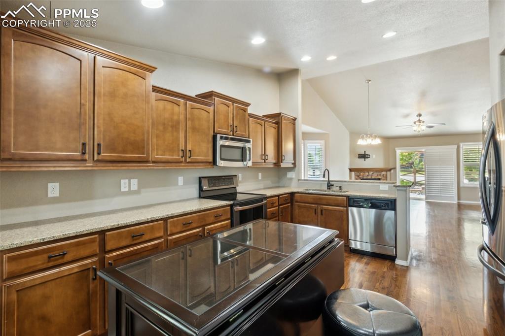 Image 4 of 50: Kitchen featuring appliances with stainless steel finishes, a sink, an isla