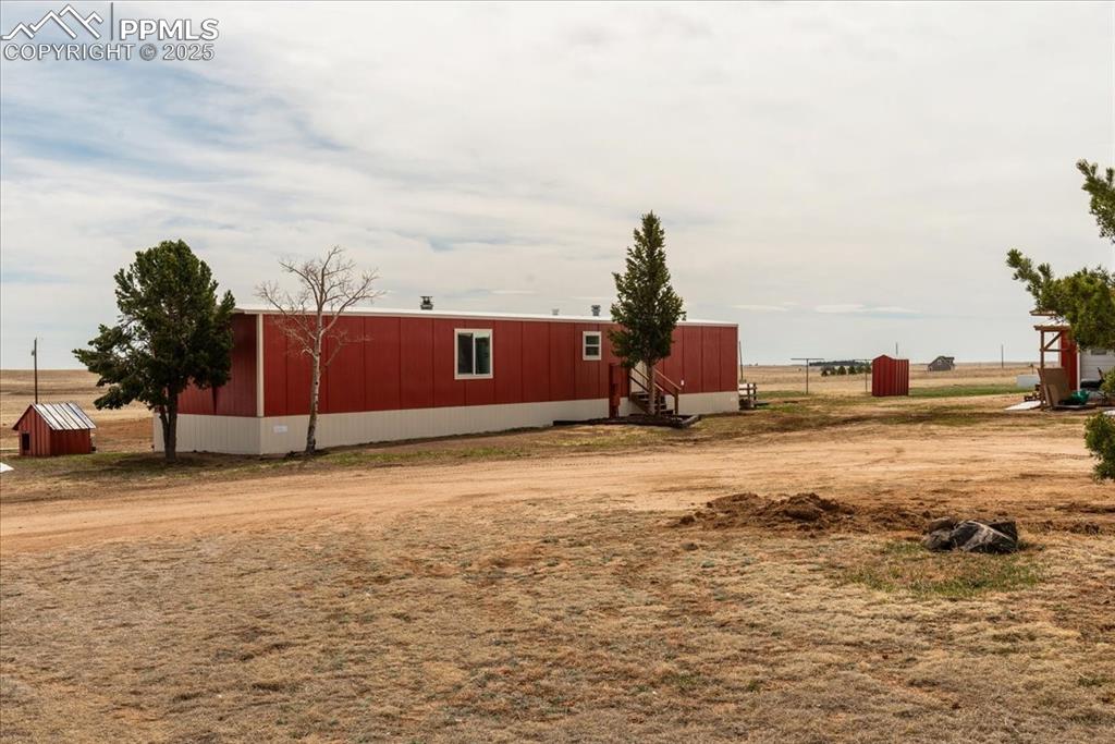 Image 21 of 50: View of yard with an outbuilding and a pole building