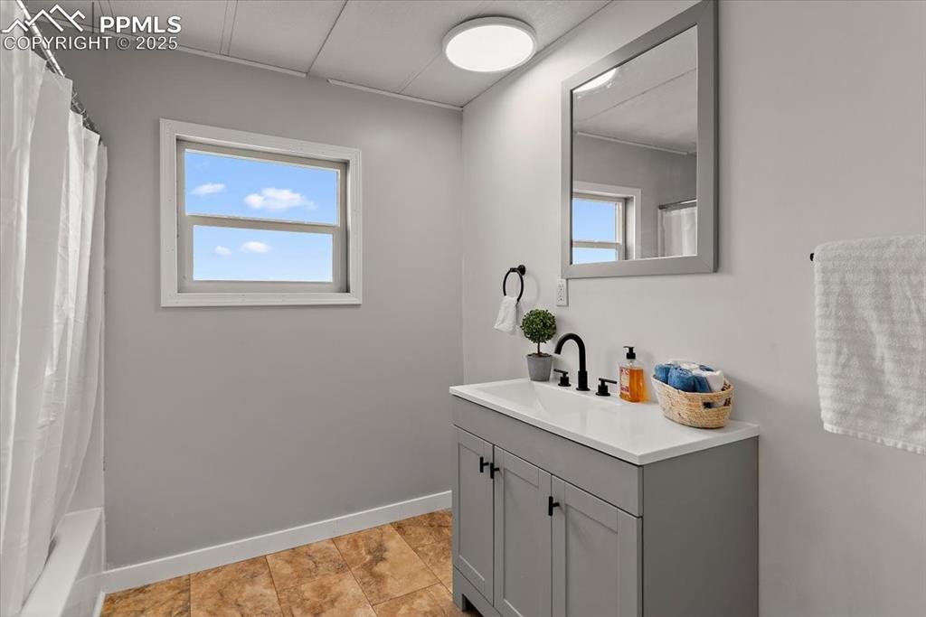 Image 35 of 50: Bathroom featuring baseboards, vanity, and a healthy amount of sunlight