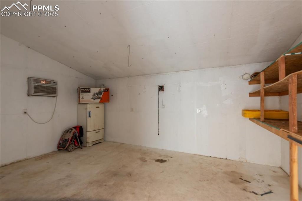 Image 41 of 50: Garage with an AC wall unit