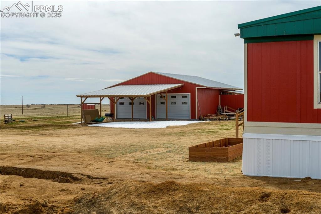 Image 44 of 50: View of yard featuring a pole building, an outbuilding, and a garage