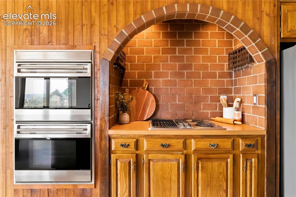 Image 10 of 49: Built-in double ovens with stainless steel finish, brick archway, integrate