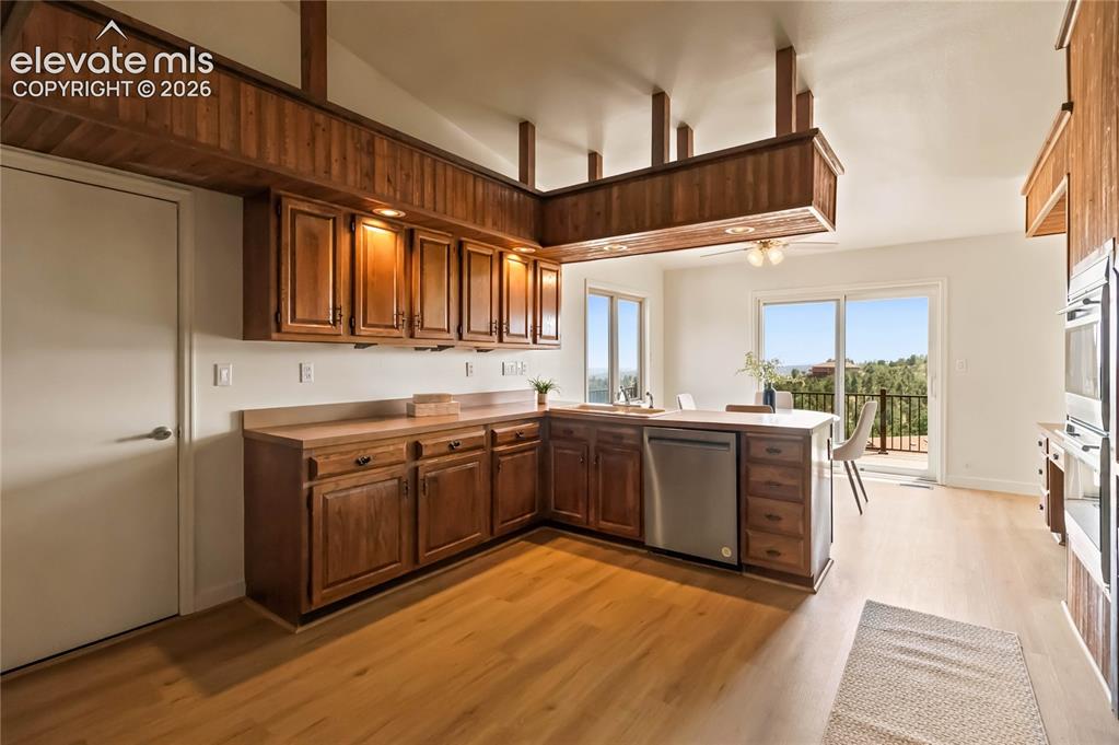 Image 11 of 49: Spacious kitchen featuring rich wood cabinetry with raised-panel doors, sta