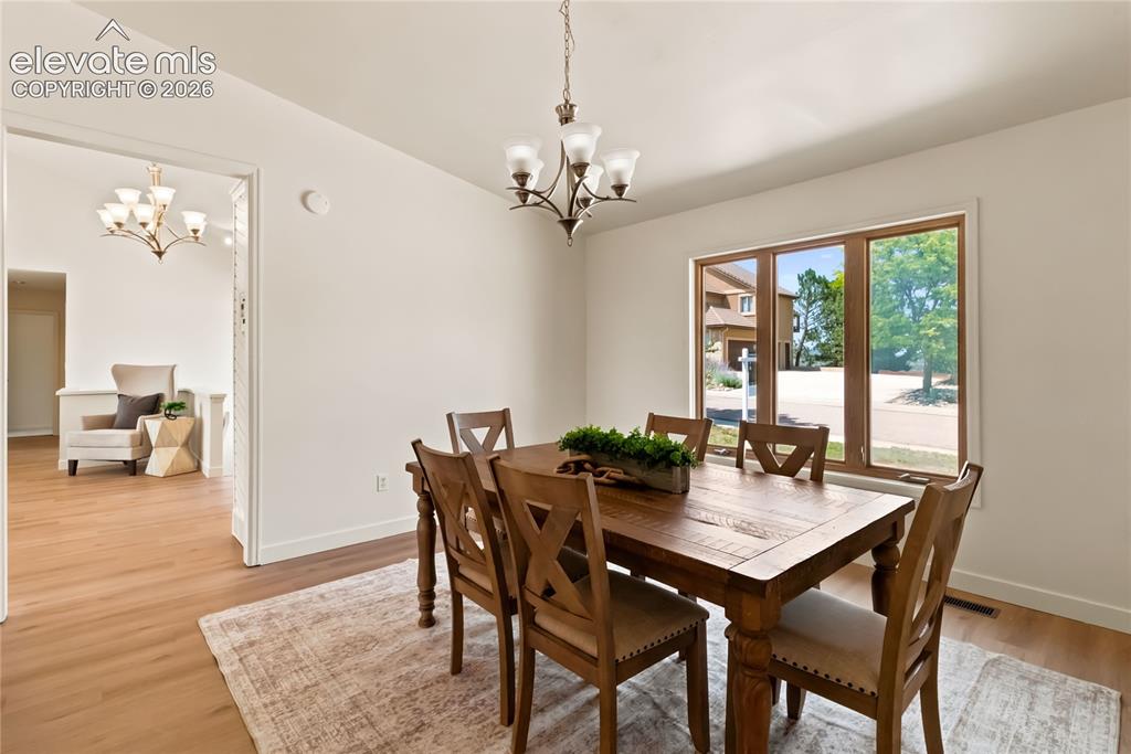 Image 13 of 49: Spacious room featuring wood-finish flooring, a multi-pane window, and a ch