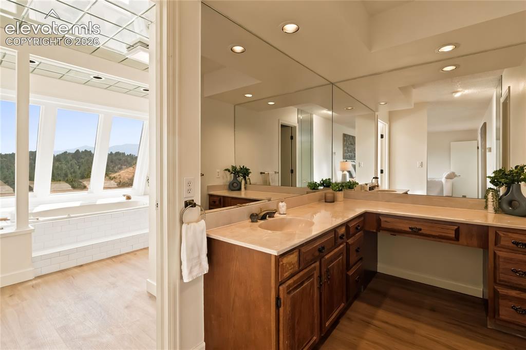 Image 22 of 49: Dual vanity with integrated sinks, expansive counter space, wood-finish cab