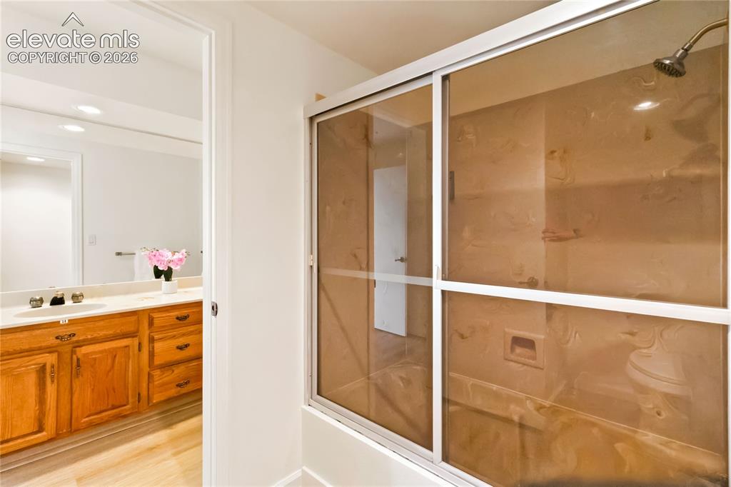 Image 35 of 49: Dual vanity with wood cabinetry and undermount sinks, full-width wall mirro
