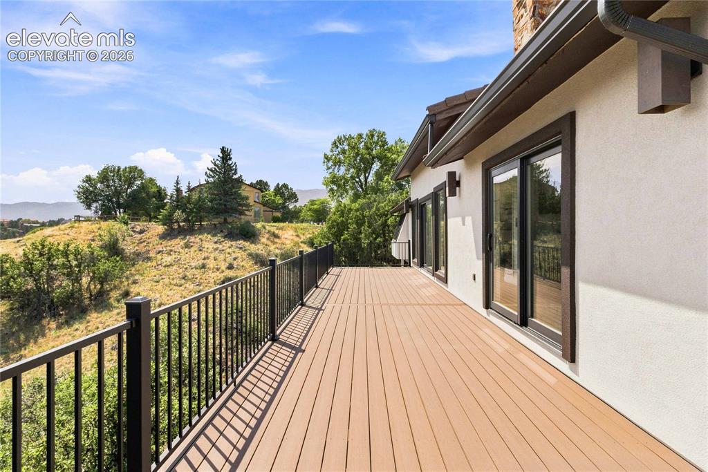 Image 36 of 49: Expansive outdoor deck with composite decking, black metal railing, multipl