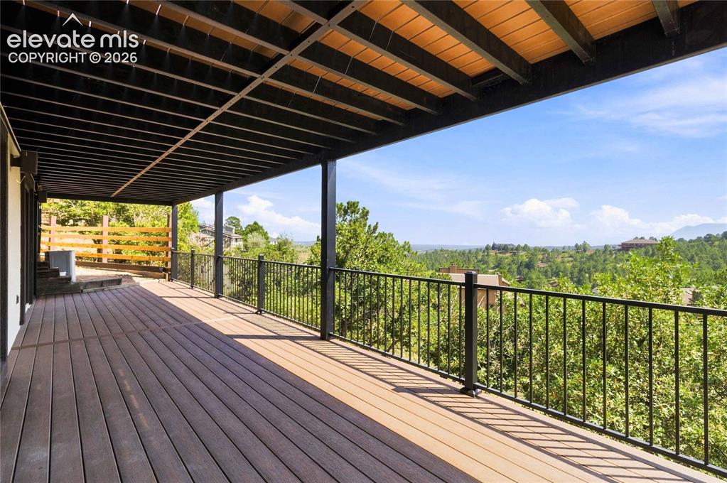 Image 38 of 49: Expansive covered deck featuring composite wood-finish flooring and a moder