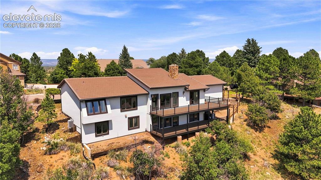 Image 45 of 49: Modern multi-level residence set on a wooded lot, featuring a contemporary