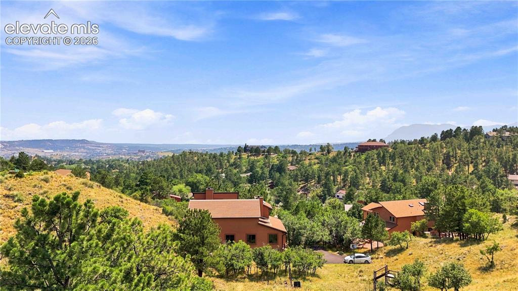 Image 47 of 49: Scenic hillside setting with mature tree-lined landscape, terracotta-toned 