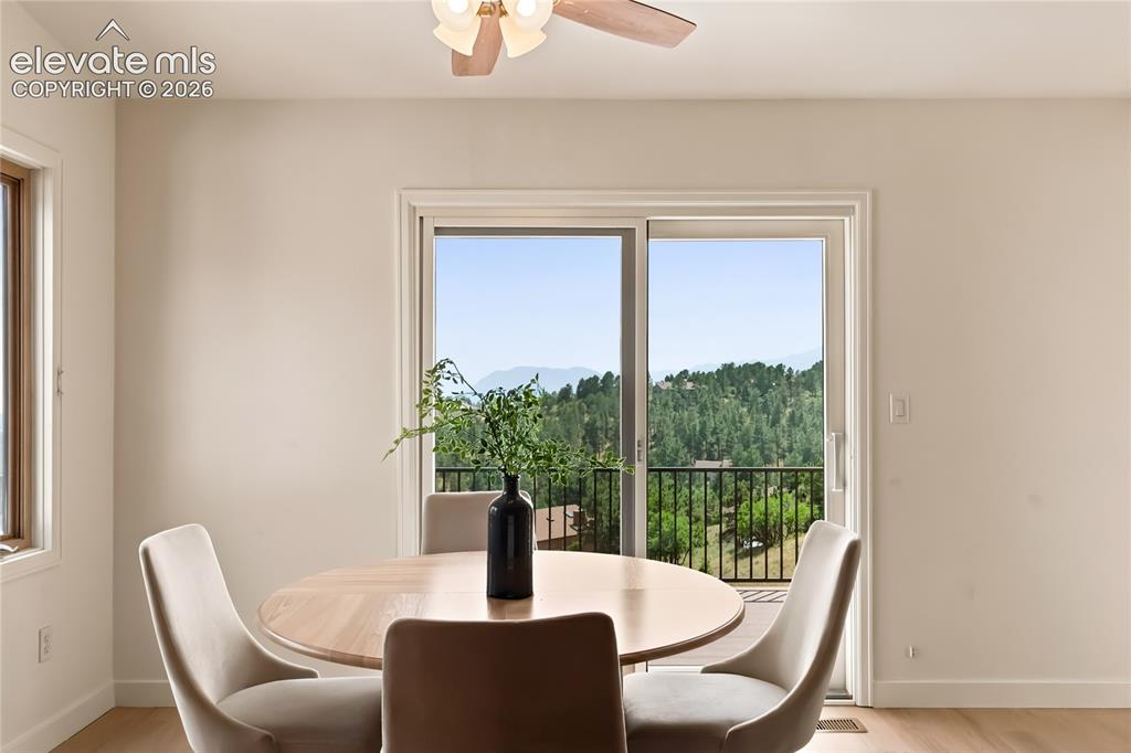 Image 9 of 49: Dining room showcasing a round wood-finish table, contemporary upholstered