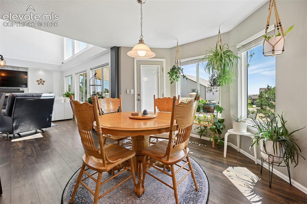 Image 10 of 36: Dining area featuring wood-finish flooring, a pendant light fixture, and la