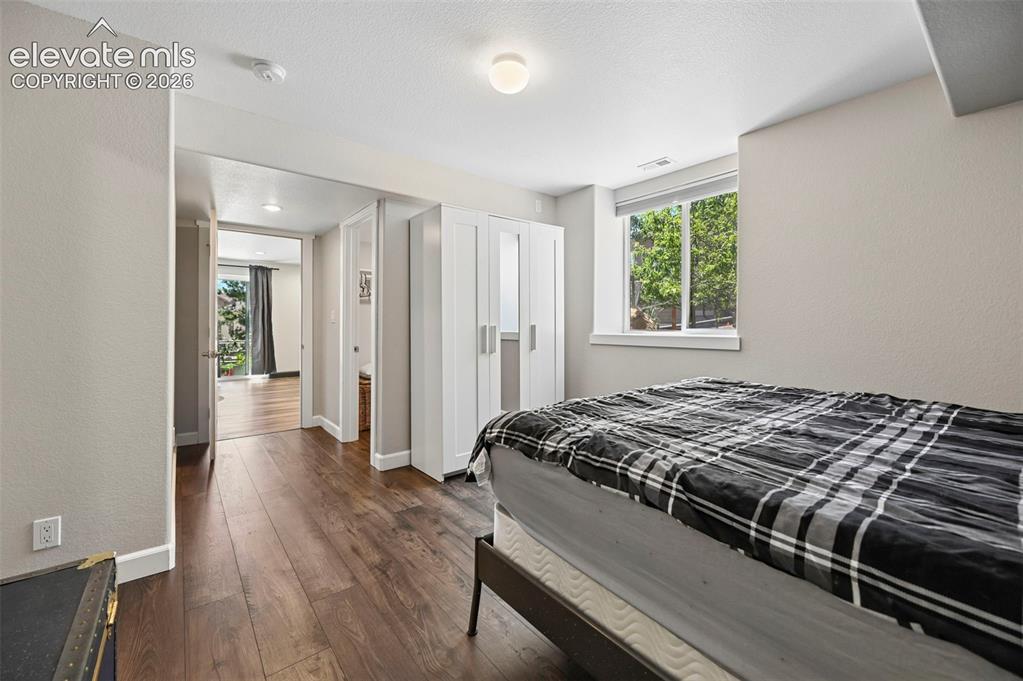 Image 19 of 36: Bedroom featuring wood-finish flooring, a contemporary ceiling light fixtur