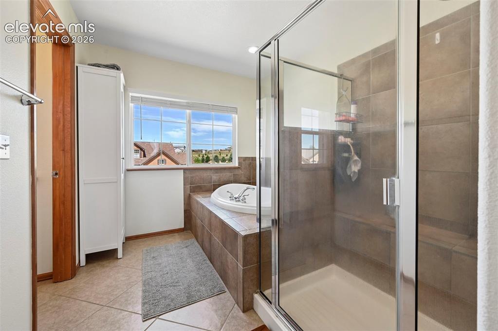 Image 23 of 36: Walk-in shower with clear glass enclosure and built-in bench