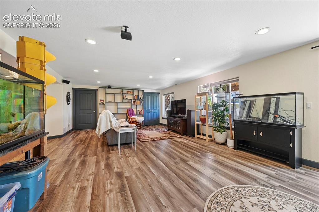 Image 28 of 36: Spacious room featuring wood-finish flooring, recessed lighting, and multip