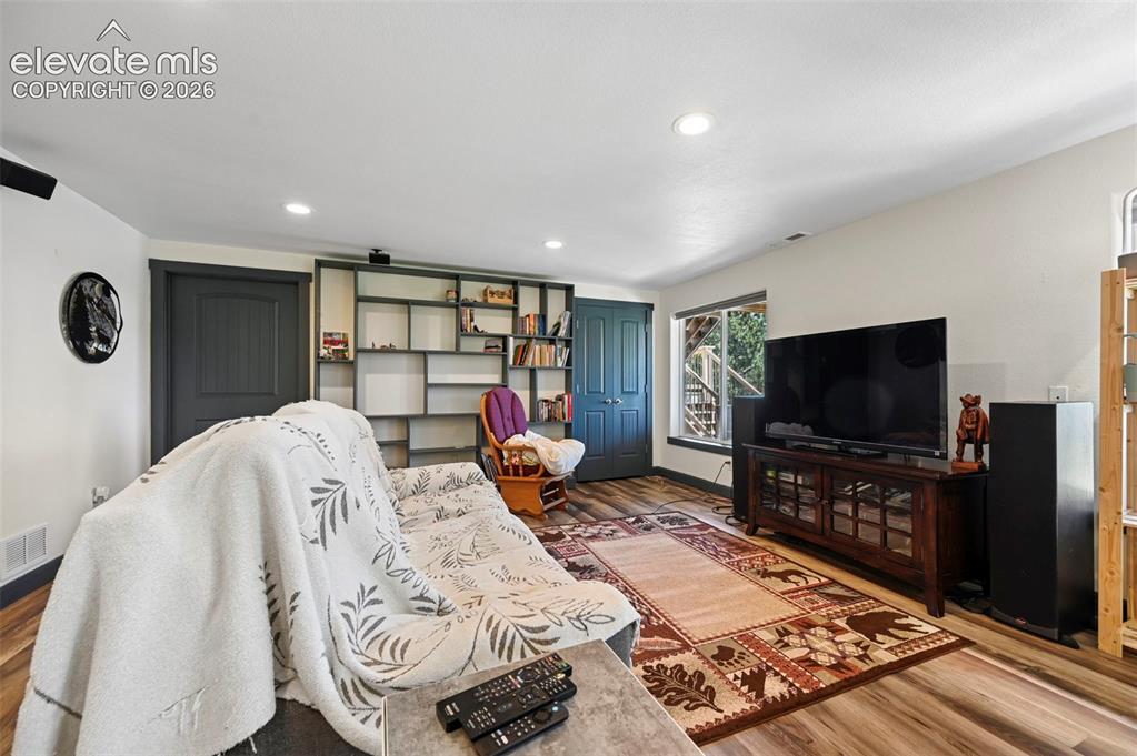 Image 29 of 36: Spacious living area featuring wood-finish flooring, recessed lighting, and