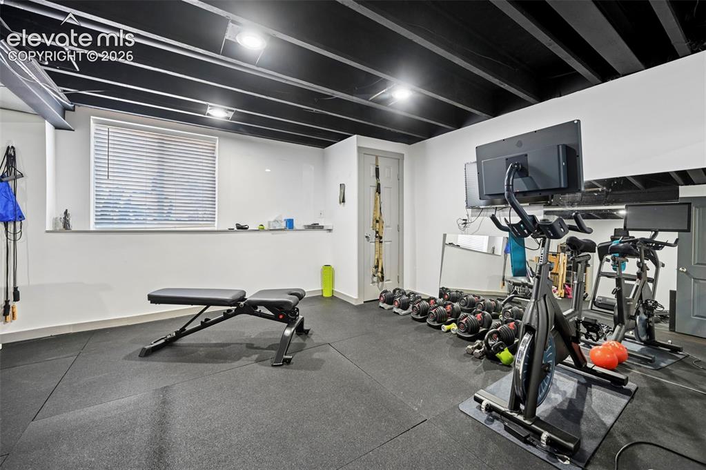 Image 31 of 36: Dedicated fitness space featuring rubber flooring, a window with horizontal