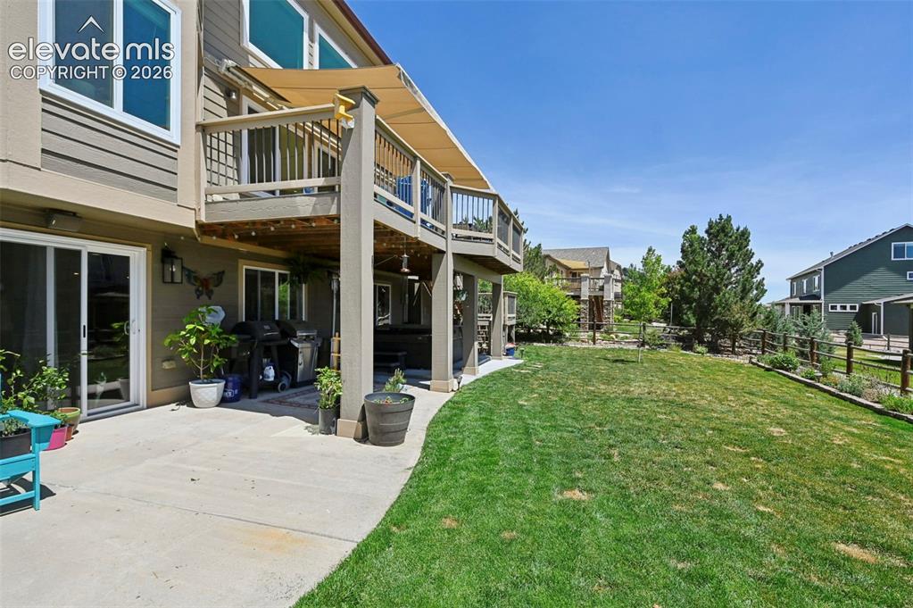 Image 36 of 36: Expansive backyard with a large concrete patio, upper-level wood deck, and 