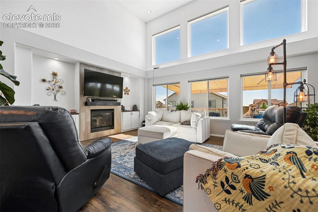 Image 5 of 36: Spacious living area featuring a fireplace with a wood-finish surround, bui