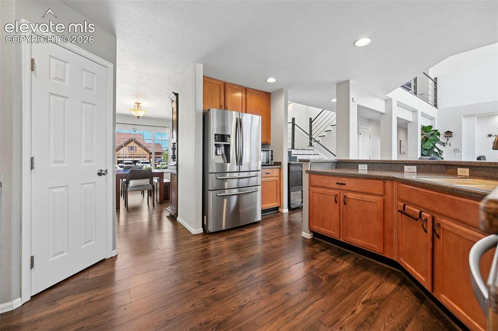 Image 8 of 36: Open-concept kitchen featuring wood-finish flooring, stainless steel refrig
