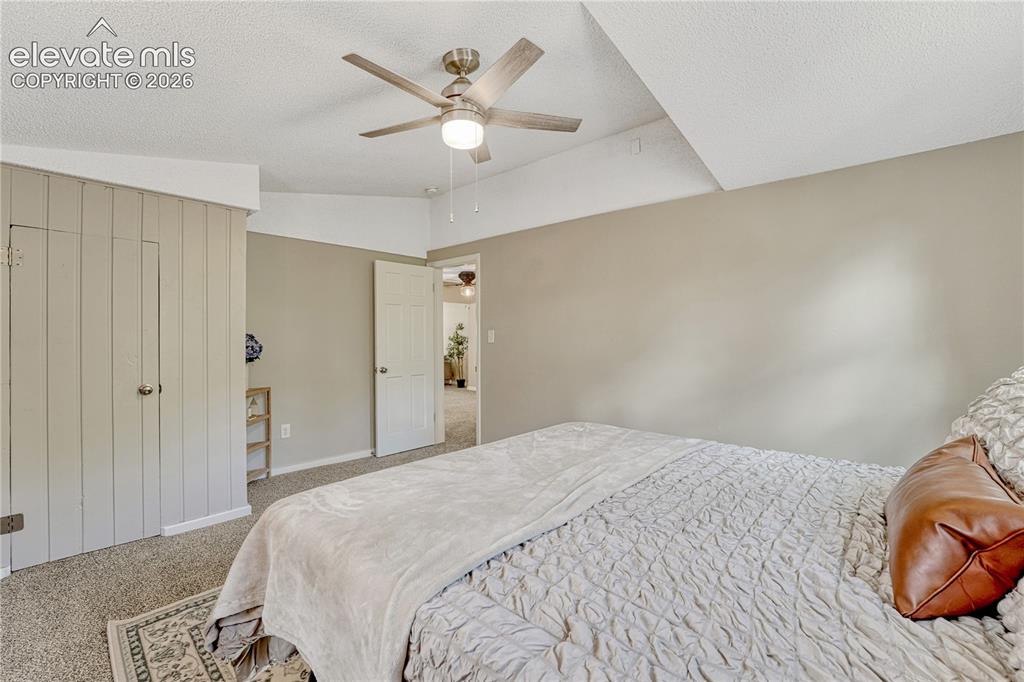 Image 14 of 41: Textured carpeting throughout, featuring a ceiling fan with integrated ligh