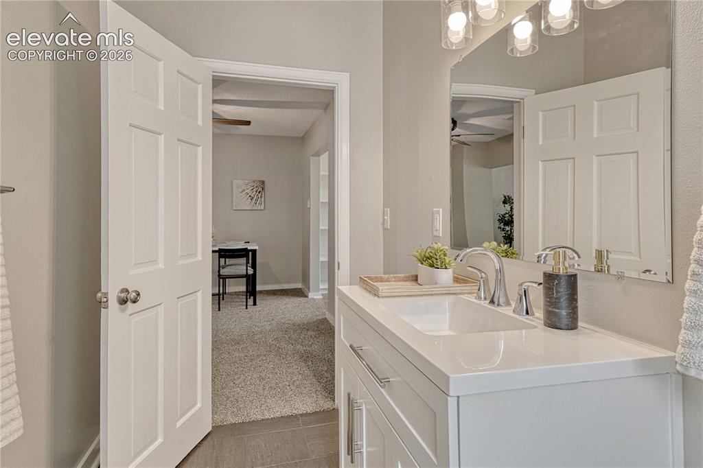 Image 15 of 41: Dual-sink vanity with white cabinetry, quartz countertop, and polished chro