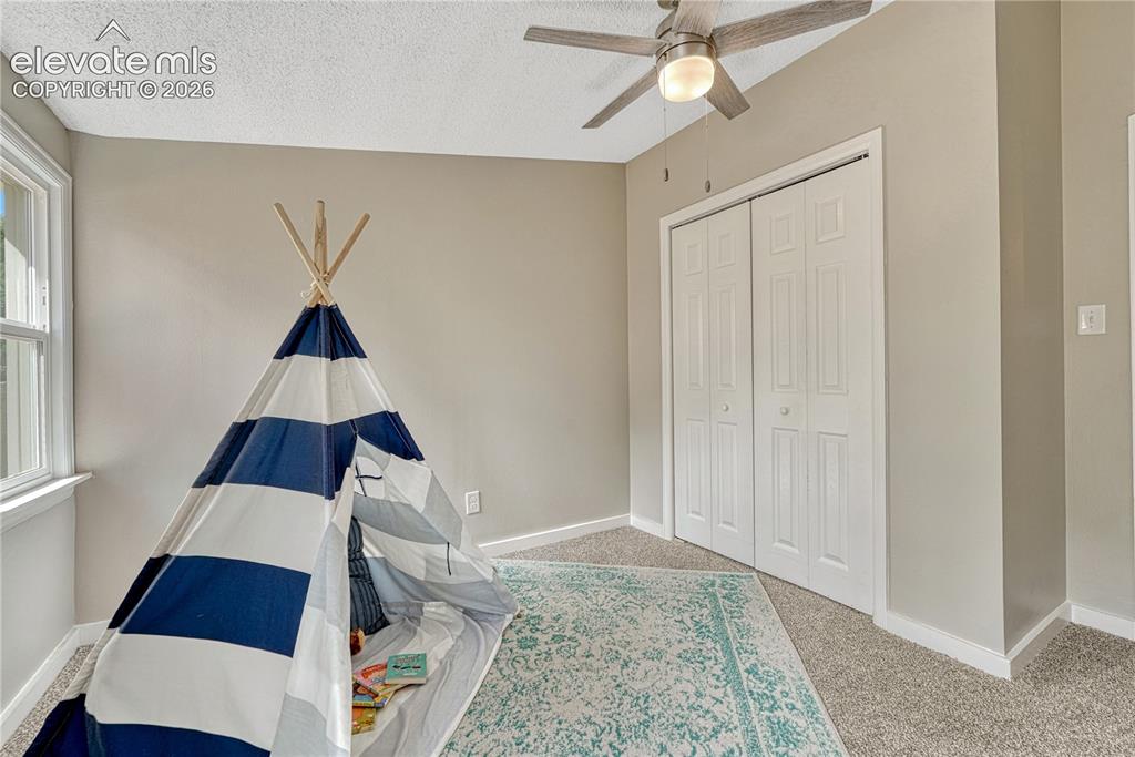 Image 16 of 41: Bright bedroom with neutral wall finishes, carpet flooring, and abundant na