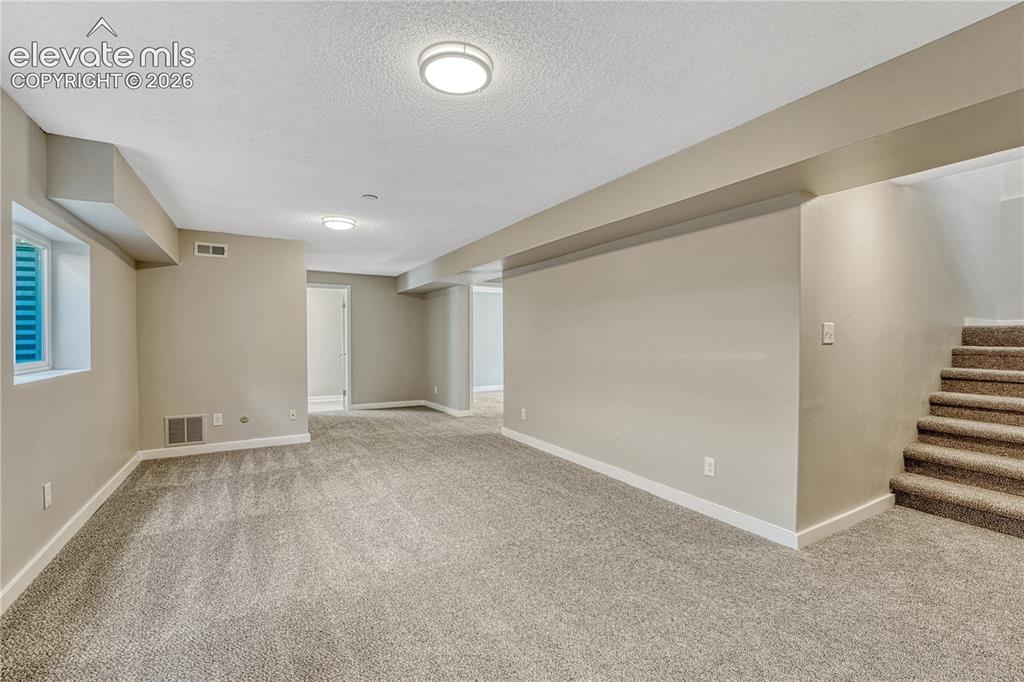Image 20 of 41: Carpeted living area with neutral wall tones, recessed lighting, and a whit