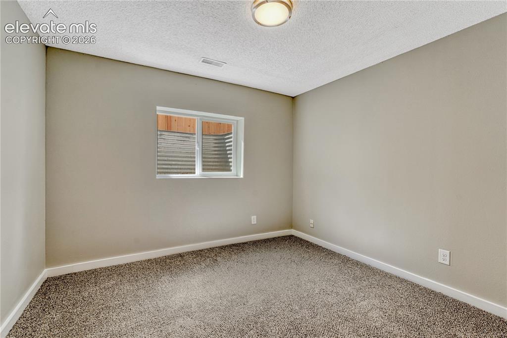 Image 26 of 41: Neutral wall color, wall-to-wall carpeting, window with a window well, and 