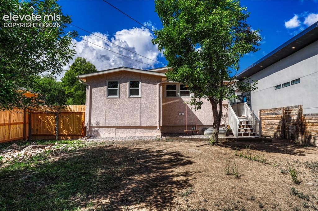 Image 28 of 41: Expansive backyard featuring a new wood fence, mature trees, and an exterio