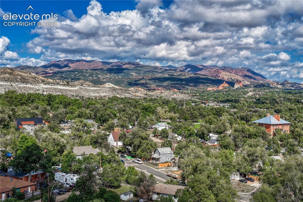 Image 40 of 41: Expansive mountain backdrop with a tree-canopied neighborhood