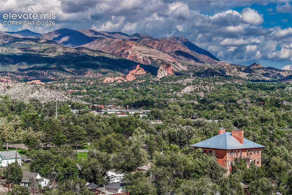 Image 41 of 41: Expansive landscape featuring distant mountains, lush green trees, and a re